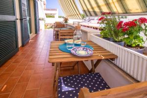 a wooden table on a balcony with glasses of water at LA CASA DEL SOLE - Beachfront B&B - Anzio in Anzio