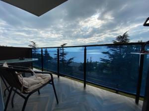 a balcony with a chair and a view of the ocean at Makhinjauri - First Line Sea View in Makhinjauri
