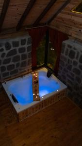 a jacuzzi tub in a room with a stone wall at Şahmaran Bungalov in Ardeşen