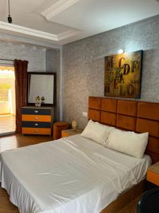 a bedroom with a large white bed and a mirror at Ouzoud le Panorama in Ouzoud