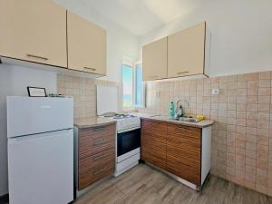 a kitchen with white appliances and wooden cabinets at Robinson Merlot in Bogomolje +75 photos