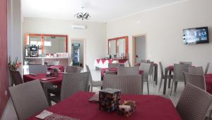a restaurant with tables and chairs with red table cloth at A'MANTIA HOTEL in Amantea