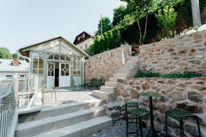 a patio with a table and chairs next to a stone wall at Apartmánový dom BiSou - Trojičné námestie in Banská Štiavnica