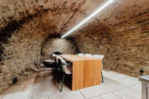 a room with a table and chairs in a brick wall at Apartmánový dom BiSou - Trojičné námestie in Banská Štiavnica