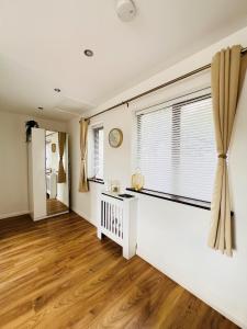 a living room with a large window and wooden floors at Studio Apartment (St Katherine’s and Wapping) in London