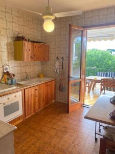 a kitchen with wooden cabinets and a sliding glass door at Casa del Fico in Santa Caterina di Nardò +27 photos
