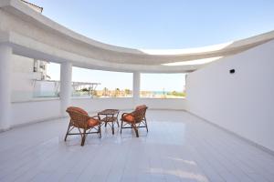 four chairs and a table on a balcony with a view at Golden Palace Marina Hotel in El Alamein