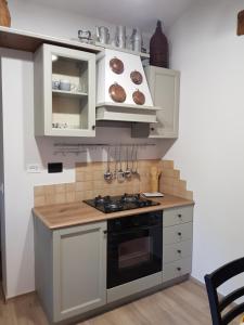 a kitchen with white cabinets and a stove top oven at Casa il Gorellino in San Giovanni Valdarno