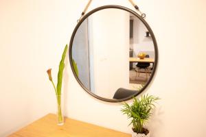 a mirror on a wall with a vase on a table at La Bora in Izola