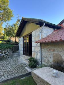 a small stone house with a window and a patio at Bosque Encantado in Beire