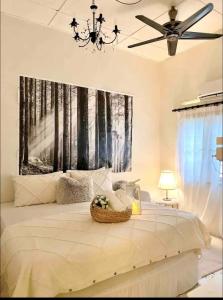 ein Schlafzimmer mit einem Bett und einem Gemälde an der Wand in der Unterkunft Cottage Near Lake Garden in Taiping
