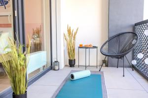 a small balcony with a blue yoga mat and a chair at Design Apartment - Balcony, Free Parking, Yoga, 10 mins to center, by Gravity Prague in Prague