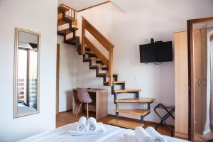 Rooms Enter Ogulin في Oštarije: غرفة نوم بها درج حلزوني وسرير وجهاز تلفزيون