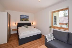 a bedroom with a bed and a couch at Seesuites am Wolfgangsee in Zinkenbach