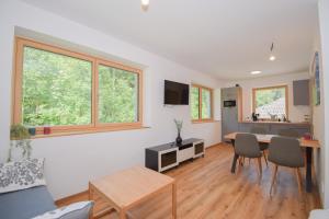a living room with a table and some chairs at Seesuites am Wolfgangsee in Zinkenbach