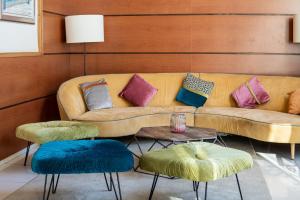a living room with a couch and two ottomans at Hotel Espanya by ALEGRIA in Calella