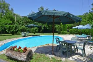 una mesa con sombrilla junto a una piscina en Molino del Ponte - Happy Rentals, en Radda in Chianti