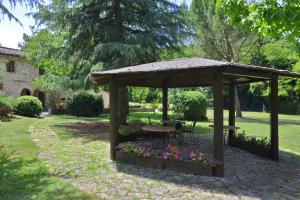 un cenador de madera con una mesa y algunas flores en Molino del Ponte - Happy Rentals, en Radda in Chianti 37 fotos más