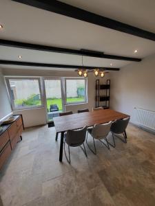 a dining room with a large wooden table and chairs at Rode Huis in Dunkerque