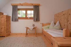 DeutschgriffenにあるKinderbauernhof Anderleのベッドルーム1室(木製ベッド1台、窓付)
