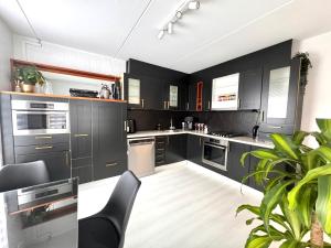 a kitchen with black cabinets and stainless steel appliances at Home with free parking near Amsterdam 45 min away! in Lelystad
