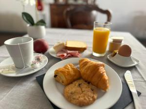 a table with a plate of pastries and a cup of orange juice at Hôtel Restaurant de France in Castelnaudary