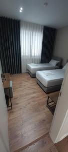 a bedroom with two beds and a wooden floor at Vila BABE in Vlorë