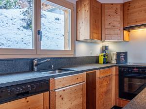 a kitchen with wooden cabinets and a sink and a window at Chalet Le Loup- le Renard et la Belette by Interhome in Nendaz +36 photos