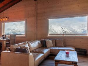 ein Wohnzimmer mit Ledersofa und zwei Fenstern in der Unterkunft Chalet Le Loup- le Renard et la Belette by Interhome in Nendaz + 36 Fotos