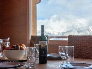 eine Flasche Wein auf einem Tisch mit Brille in der Unterkunft Chalet Le Loup- le Renard et la Belette by Interhome in Nendaz