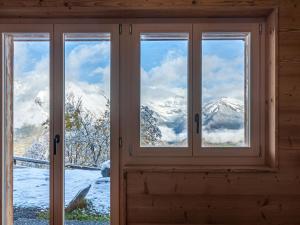 ein Fenster mit Blick auf die schneebedeckten Berge in der Unterkunft Chalet Le Loup- le Renard et la Belette by Interhome in Nendaz