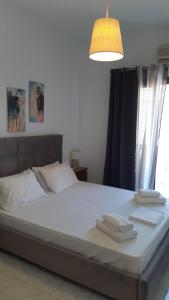 a bed with white sheets and towels on it at Ενάλιον in Astypalaia