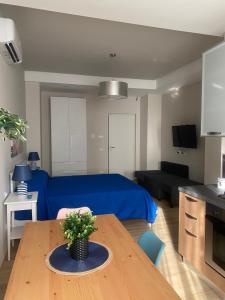 a living room with a blue bed and a table at Leila's Home in Gaeta