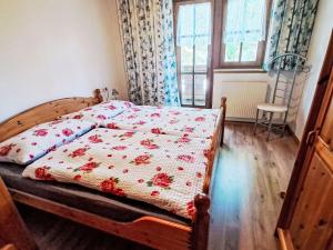 a bedroom with a bed with a flowered blanket on it at Apartment Nicole by Interhome in Maishofen
