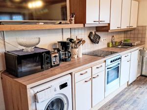 a kitchen with a microwave and a washer and dryer at Apartment Nicole by Interhome in Maishofen