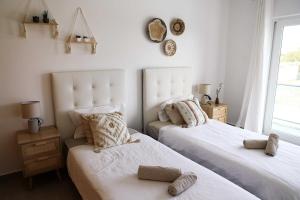 Un dormitorio con dos camas y una ventana. en Sunset apartment Peniche Surfcamp, en Ferrel