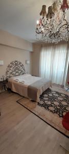 Un dormitorio con una cama grande y una lámpara de araña. en Central luxury rooms, en Olbia