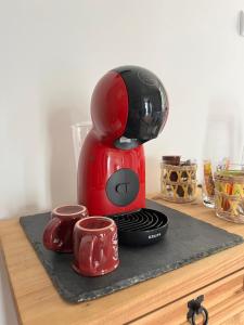 a red coffee maker sitting on top of a counter at Maison La Glycine in Chamoux-sur-Gelon