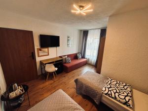 a hotel room with a couch and a tv at Pensjonat Pod Wozem in Trzebiatów