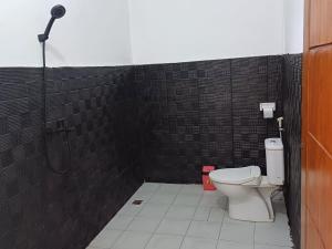 a bathroom with a shower and a toilet in it at Black Sweet Homestay Dua in Gili Islands