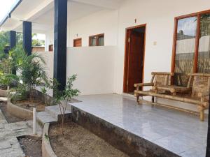 a porch of a house with a bench on it at Black Sweet Homestay Dua in Gili Air