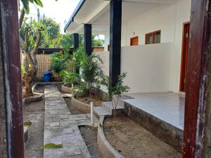 a house with a courtyard with potted plants at Black Sweet Homestay Dua in Gili Islands