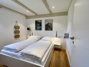 a bedroom with a bed with white sheets at Holiday Home Melvill by Interhome in Dittishausen