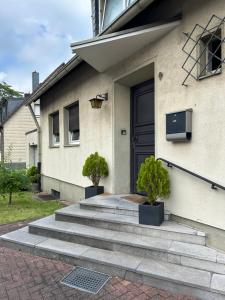 a house with two potted trees in front of a door at Apartment im Düsseldorfer Norden in Düsseldorf