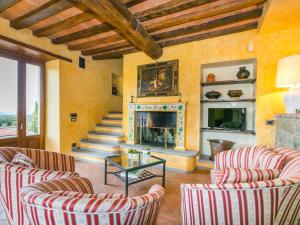 a living room with two chairs and a fireplace at Holiday Home Il Borgo di Savignola by Interhome in Greve in Chianti