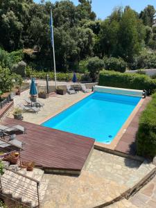 a large swimming pool with a wooden deck and chairs at Résidence Le Golfe Bleu in Rayol-Canadel-sur-Mer
