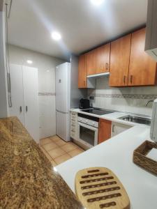 una cucina con mobili in legno e un piano di lavoro di Retiro MonteMar a La Manga del Mar Menor Altre 33 foto