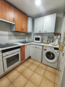 una cucina con lavatrice e microonde di Retiro MonteMar a La Manga del Mar Menor