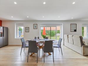 a dining room with a table and chairs and a couch at Holiday Home La Bergerie by Interhome in Créances +20 photos