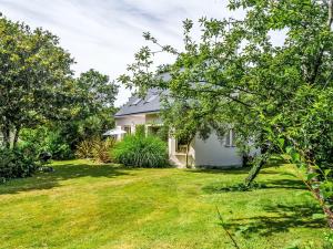 a white house with a yard in front of it at Holiday Home Maison de Locmaria by Interhome in Ploemel